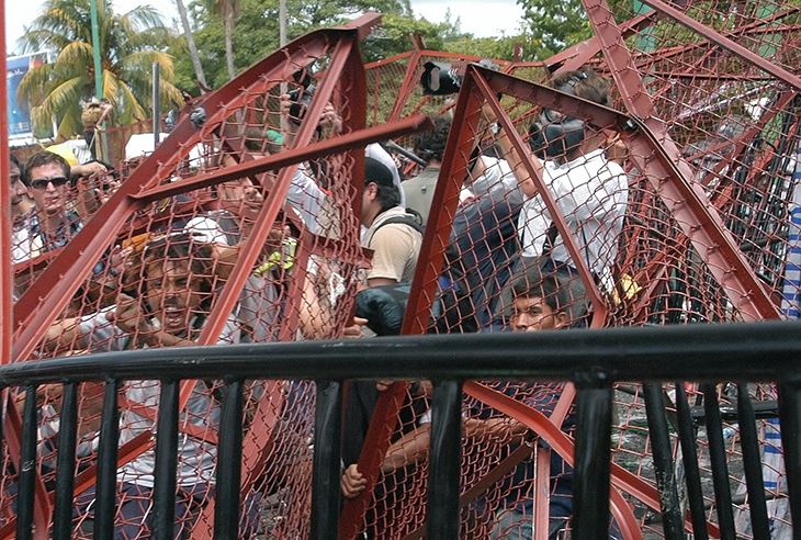 Protesters tear down fences after a South Korean farmer committed suicide moments earlier.
